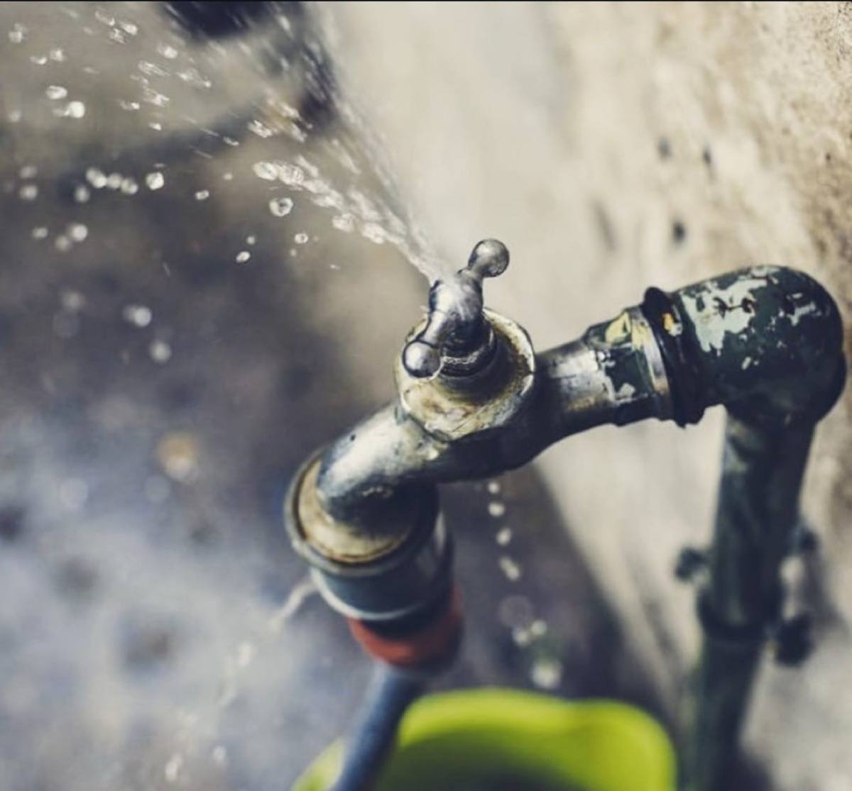 A leaking tap spraying water against a wall